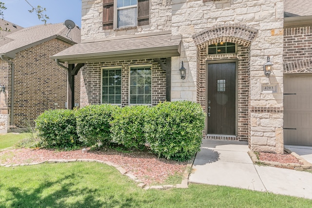 property entrance featuring a garage and a yard