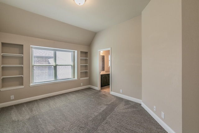 unfurnished bedroom with lofted ceiling, connected bathroom, and carpet