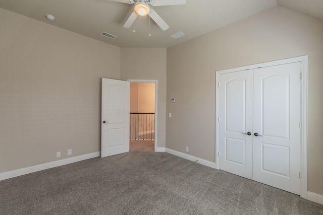 unfurnished bedroom with vaulted ceiling, a closet, ceiling fan, and carpet