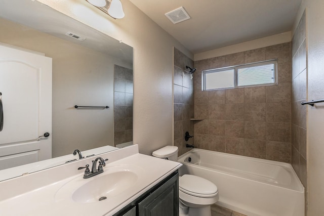 full bathroom with tiled shower / bath, vanity, and toilet