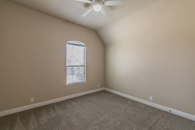 empty room featuring ceiling fan, lofted ceiling, and carpet