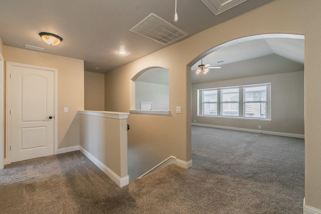 hall featuring lofted ceiling and dark carpet