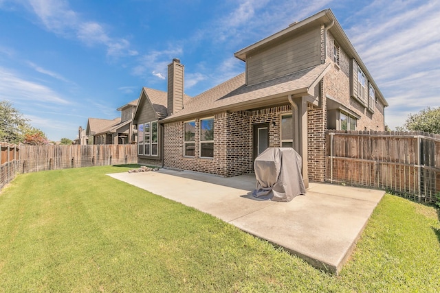 rear view of property featuring a yard and a patio