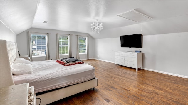 bedroom featuring lofted ceiling, hardwood / wood-style floors, and a chandelier