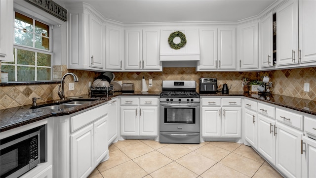 kitchen with decorative backsplash, white cabinets, sink, light tile patterned flooring, and stainless steel appliances