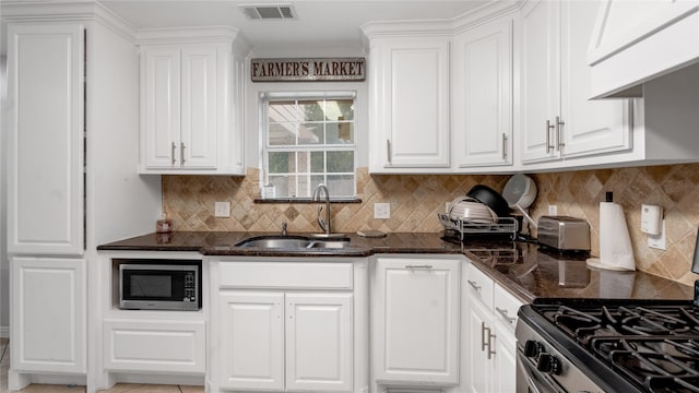 kitchen with sink, stainless steel appliances, white cabinets, and tasteful backsplash