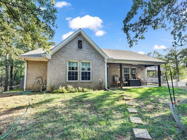 back of property with a patio area and a yard