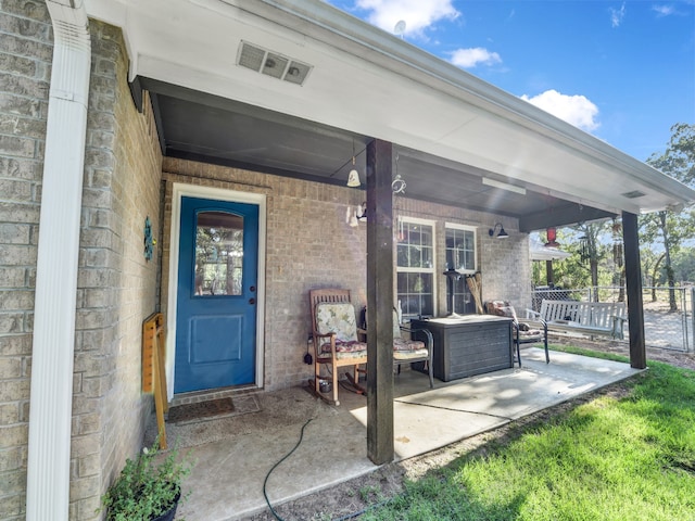 doorway to property with ceiling fan and a patio