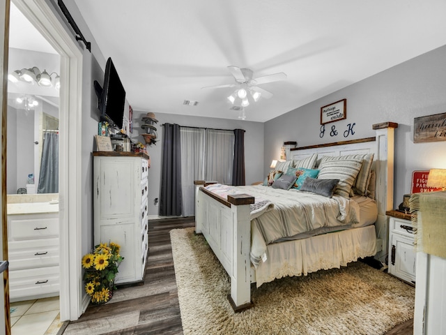 bedroom featuring ceiling fan, dark hardwood / wood-style floors, and ensuite bath