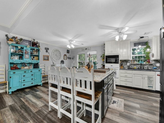 kitchen featuring ceiling fan, dark hardwood / wood-style floors, black microwave, and a healthy amount of sunlight