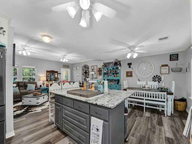 kitchen with gray cabinetry, a center island, dark wood-type flooring, and ceiling fan