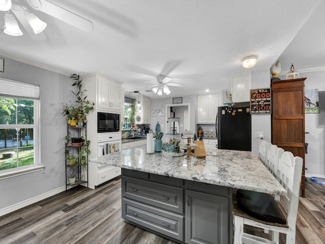 kitchen featuring white cabinetry, wood-type flooring, ceiling fan, and black appliances