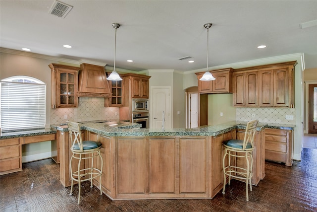 kitchen with a kitchen island, a kitchen breakfast bar, appliances with stainless steel finishes, and custom range hood