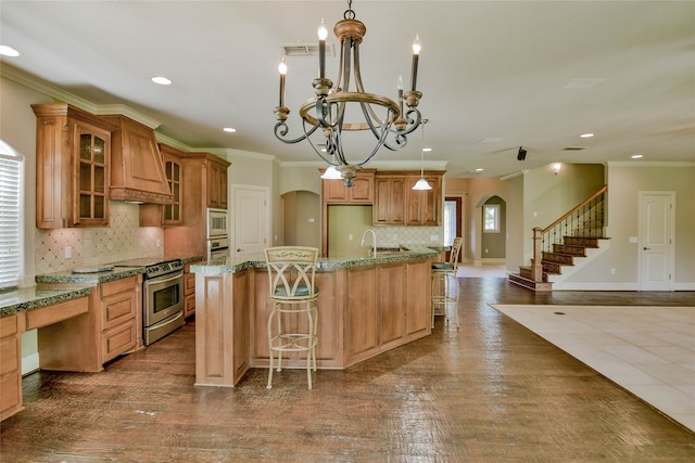 kitchen with stainless steel appliances, dark wood-type flooring, an island with sink, and custom exhaust hood