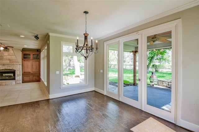 entryway with hardwood / wood-style flooring, a fireplace, crown molding, and ceiling fan with notable chandelier