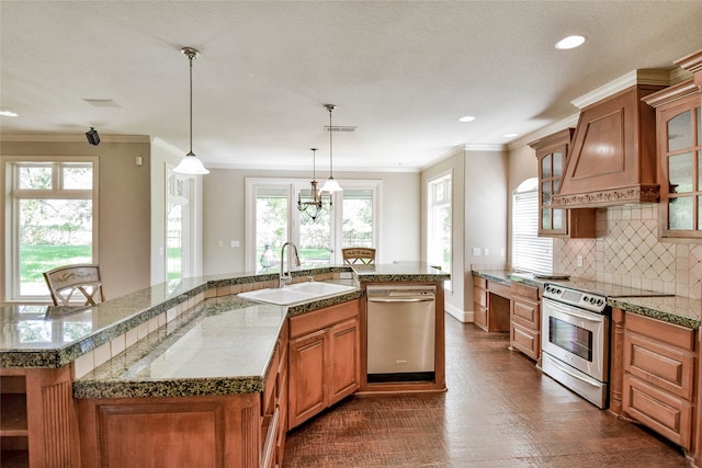 kitchen featuring a kitchen island with sink, appliances with stainless steel finishes, a healthy amount of sunlight, and ornamental molding