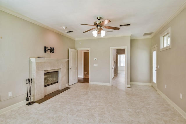 unfurnished living room with ceiling fan, crown molding, a tile fireplace, and tile patterned floors