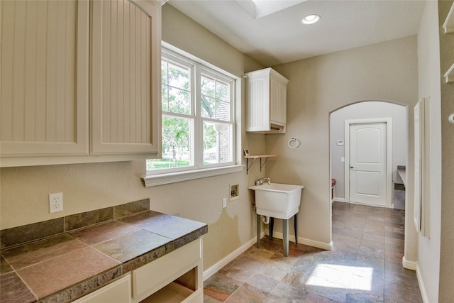 laundry room featuring light tile patterned floors, cabinets, and hookup for a washing machine