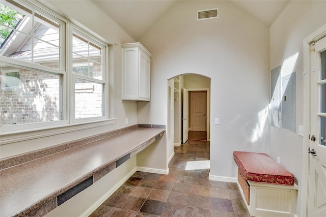 interior space with high vaulted ceiling and dark tile patterned floors