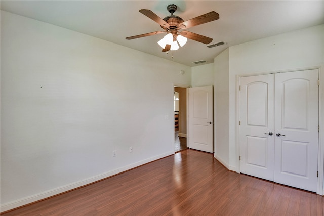 unfurnished bedroom with a closet, ceiling fan, and hardwood / wood-style floors