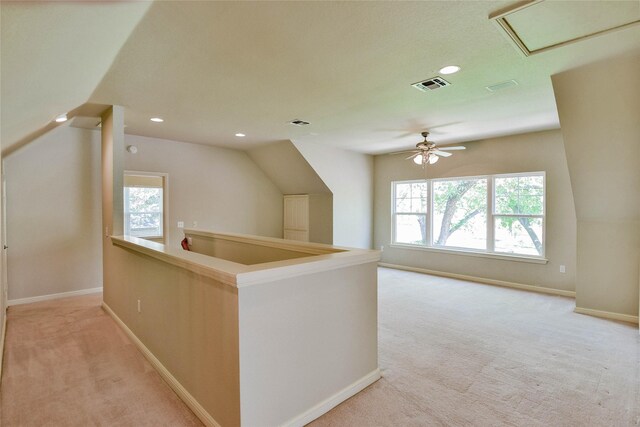 interior space with light colored carpet, plenty of natural light, and lofted ceiling