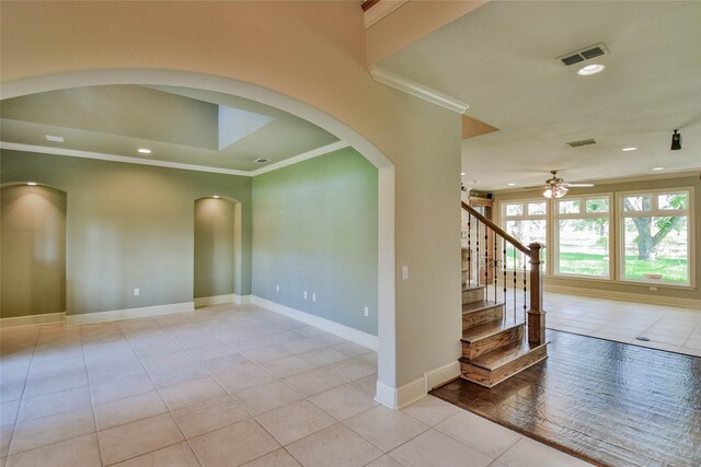 tiled spare room featuring ceiling fan and crown molding