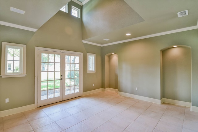 tiled empty room featuring a high ceiling, ornamental molding, and french doors