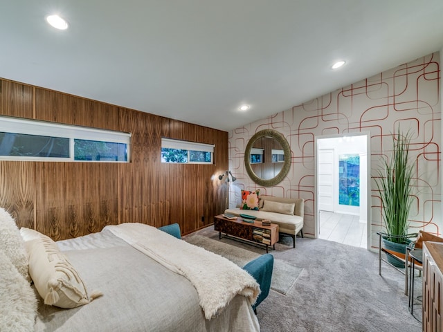 carpeted bedroom featuring wood walls