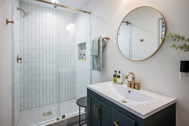 bathroom with tiled shower and vanity