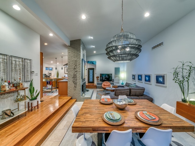 dining space with vaulted ceiling, a chandelier, and light tile patterned flooring