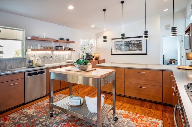 kitchen with hanging light fixtures, dishwasher, hardwood / wood-style flooring, and decorative backsplash