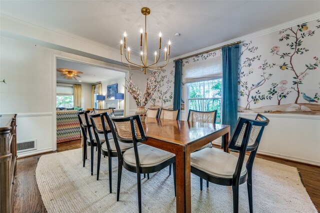 dining room featuring ornamental molding, hardwood / wood-style floors, a notable chandelier, and a wealth of natural light