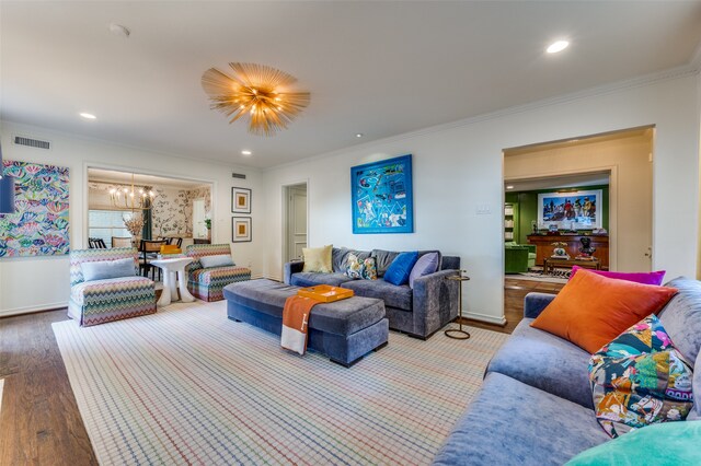 living room featuring crown molding, hardwood / wood-style floors, and a chandelier