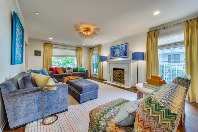 living room featuring ornamental molding, hardwood / wood-style floors, and a high end fireplace