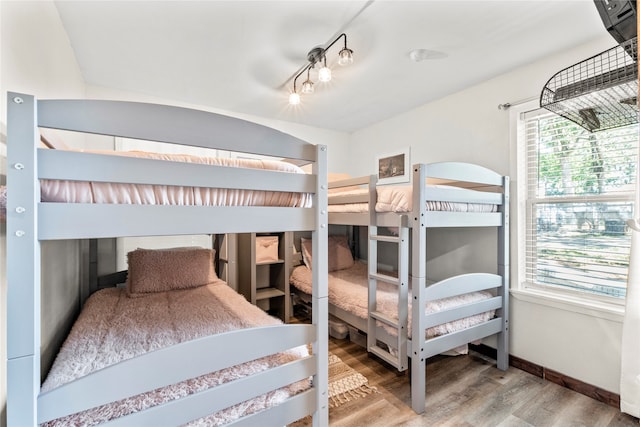 bedroom featuring hardwood / wood-style flooring and track lighting