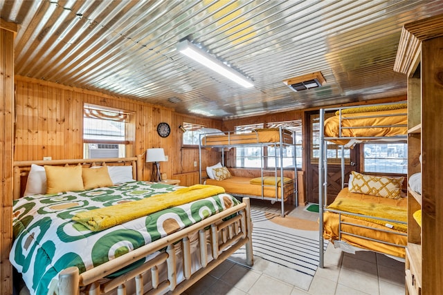 tiled bedroom featuring wooden walls, multiple windows, and cooling unit