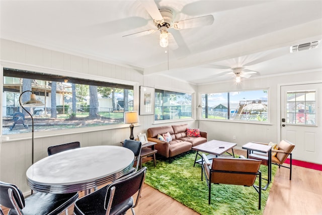 living room featuring ceiling fan, light wood-type flooring, and beam ceiling