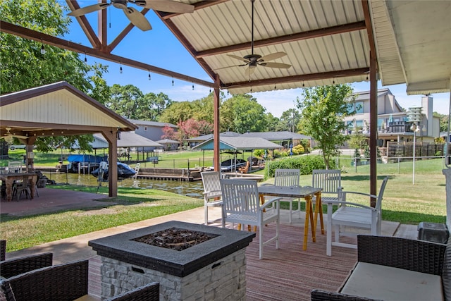 view of patio with ceiling fan and a fire pit