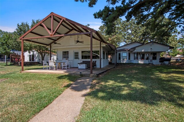 rear view of property with ceiling fan, a patio area, and a yard