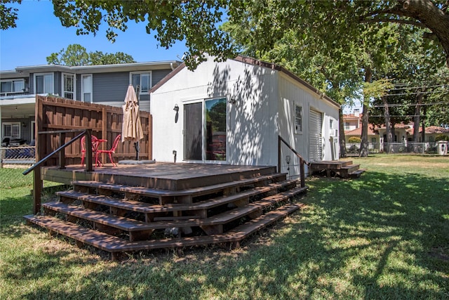 back of house featuring a deck and a lawn