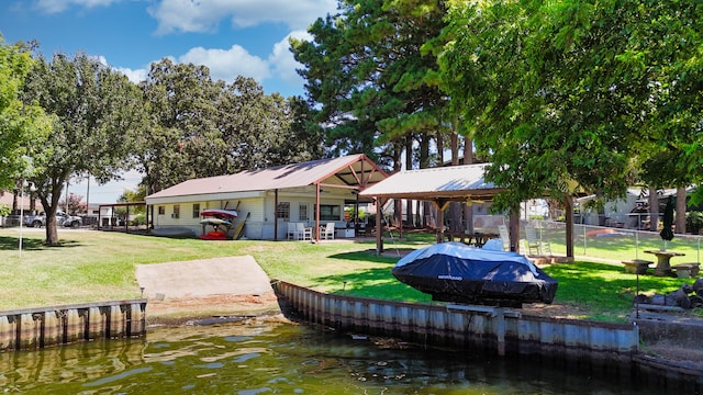 exterior space featuring a patio, a lawn, and a water view