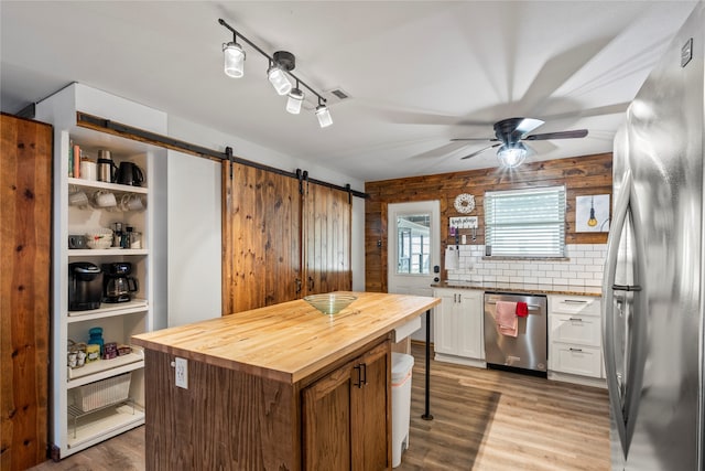 kitchen with wood counters, appliances with stainless steel finishes, light wood-type flooring, ceiling fan, and white cabinetry