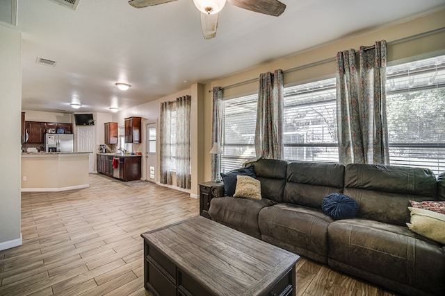 living room with ceiling fan and light hardwood / wood-style floors