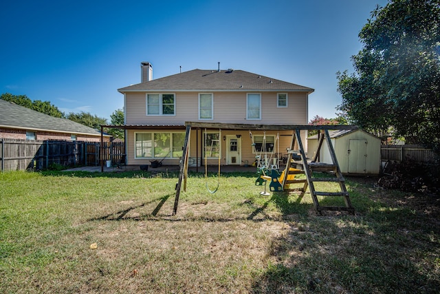 rear view of house with a shed and a lawn