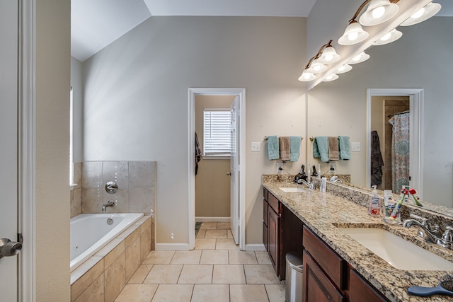 bathroom featuring dual vanity, tiled tub, tile patterned flooring, and lofted ceiling