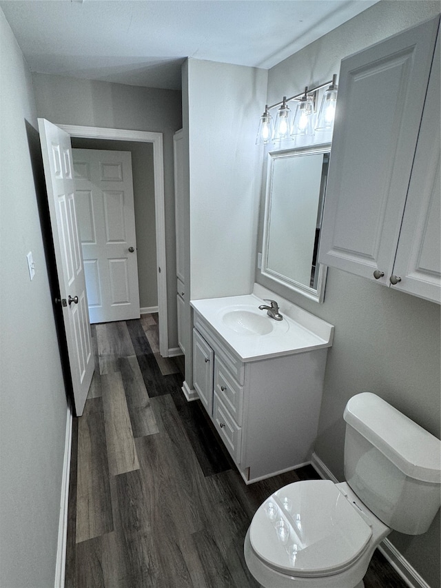 bathroom featuring vanity, toilet, and hardwood / wood-style flooring