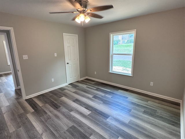 unfurnished room featuring dark wood-type flooring and ceiling fan