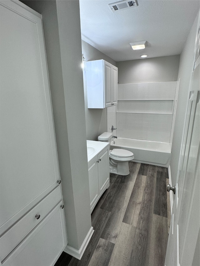 full bathroom featuring toilet, vanity, a textured ceiling, hardwood / wood-style flooring, and shower with separate bathtub