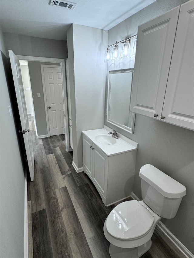 bathroom with hardwood / wood-style floors, toilet, and vanity