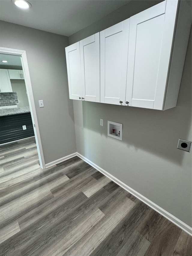 washroom with washer hookup, hookup for an electric dryer, dark hardwood / wood-style floors, and cabinets